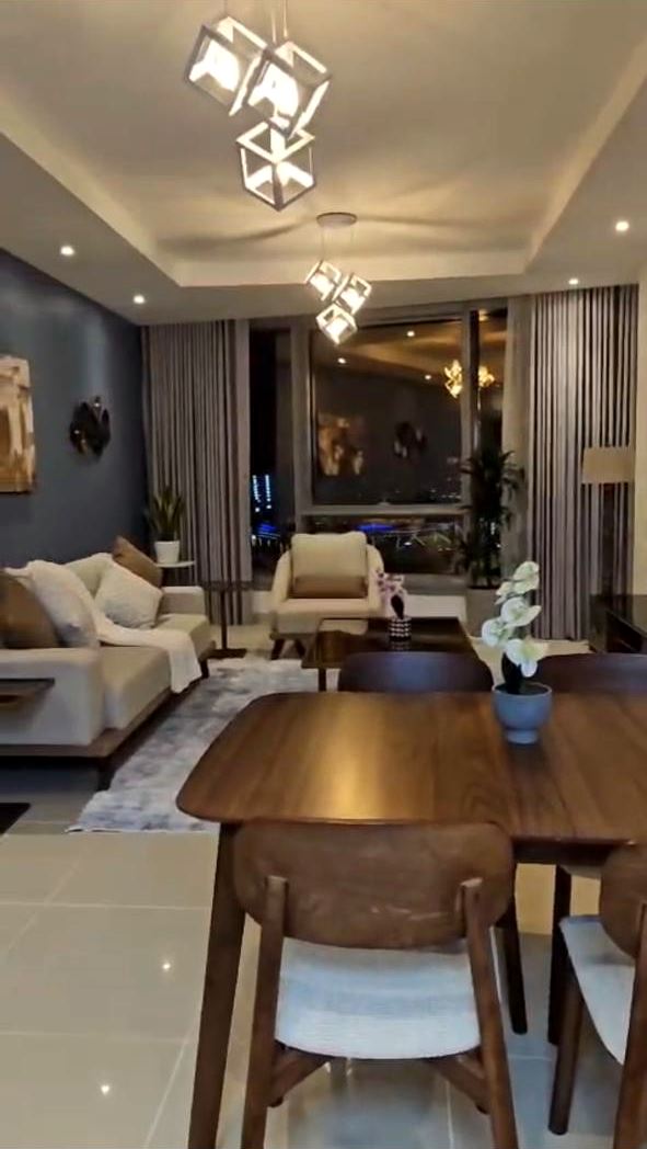 Renovated living and dining room with cove-lit ceiling and cube pendant lights