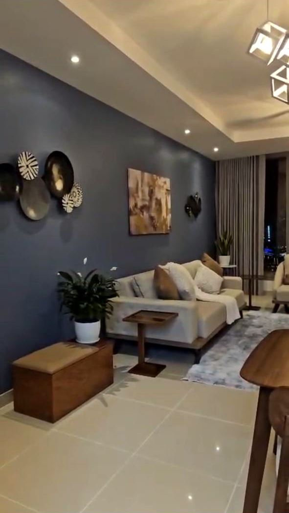 Living room with a deep blue painted feature wall and recessed ceiling lights