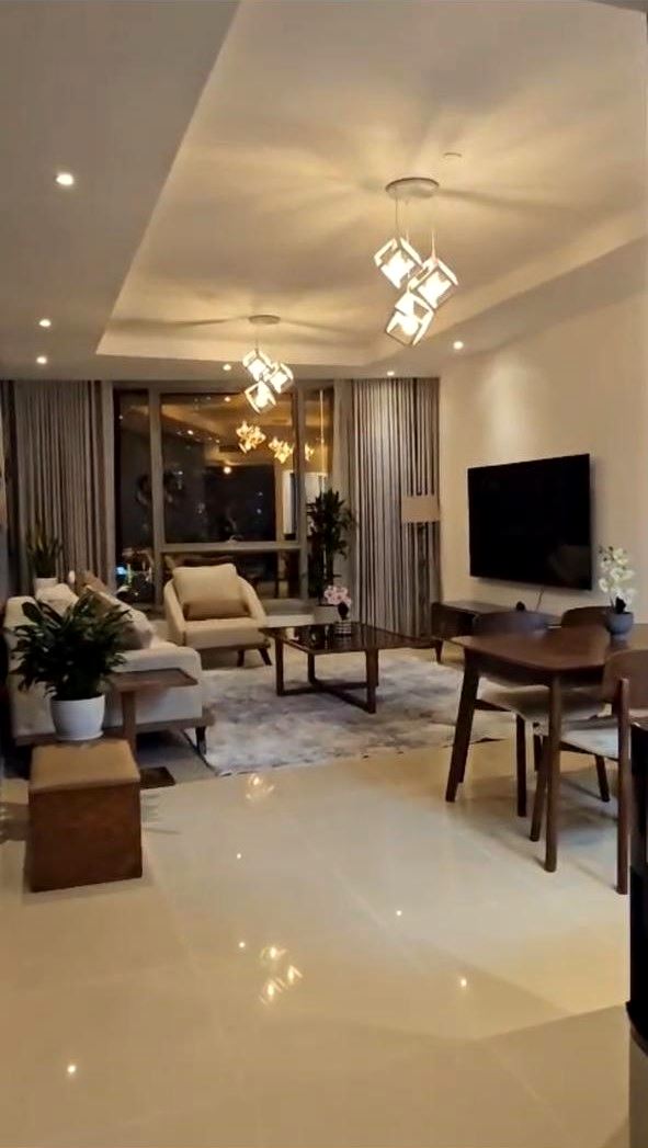 Living room with cove-lit gypsum ceiling, pendant lights and polished floor tiles