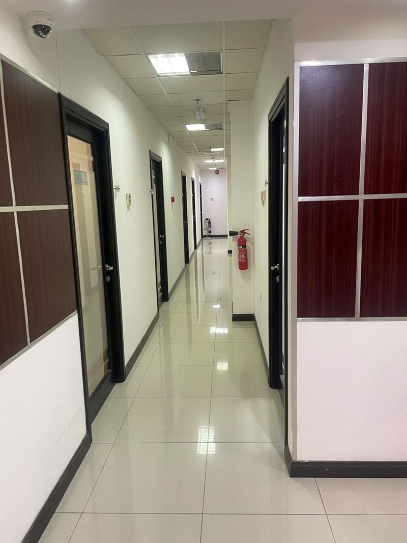 Commercial office corridor with suspended ceiling and polished floor tiles