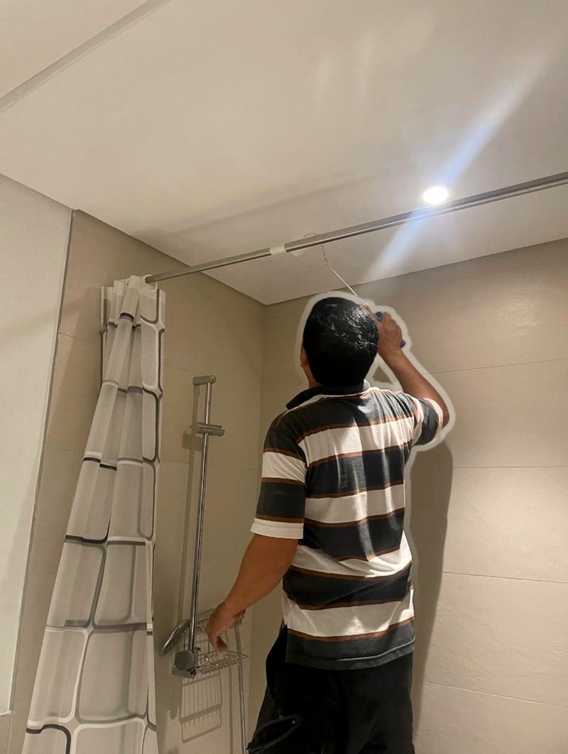 Technician installing a fitting on a bathroom ceiling